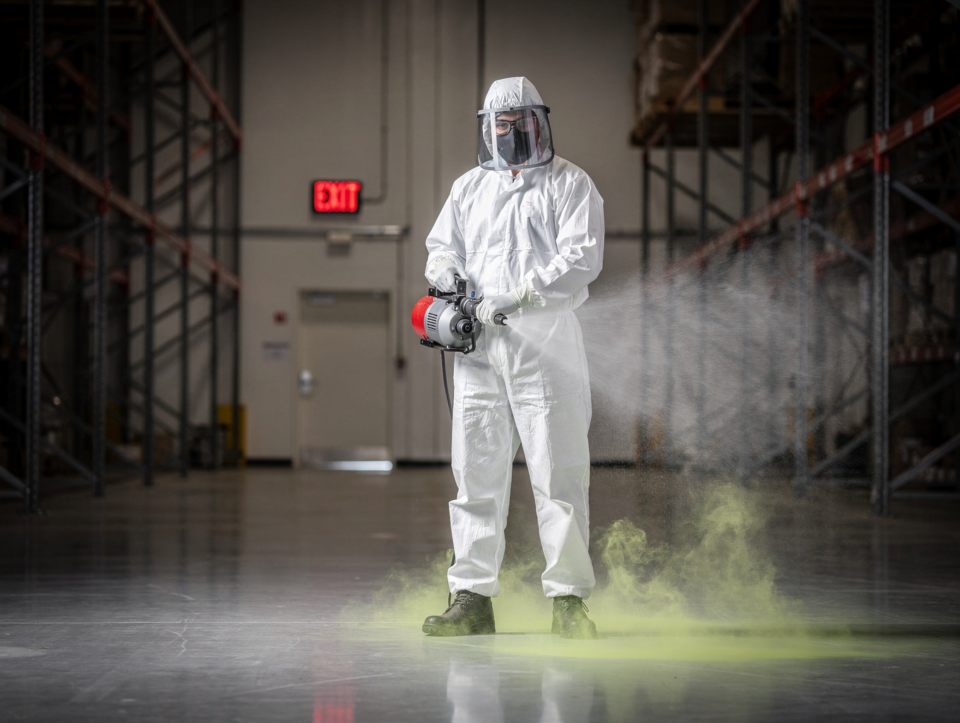 Certified professional pest-control technician in PPE carrying out commercial treatment